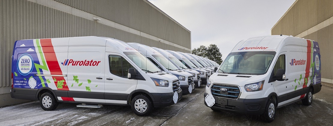 Purolator's fully electric van fleet in front of a terminal