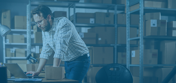 Dock manager working on a laptop in a warehouse