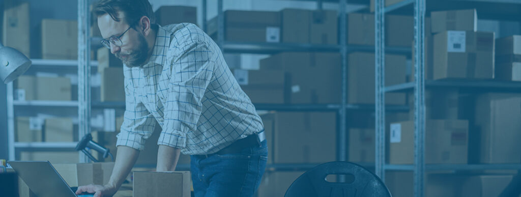 Dock manager working on a laptop in a warehouse