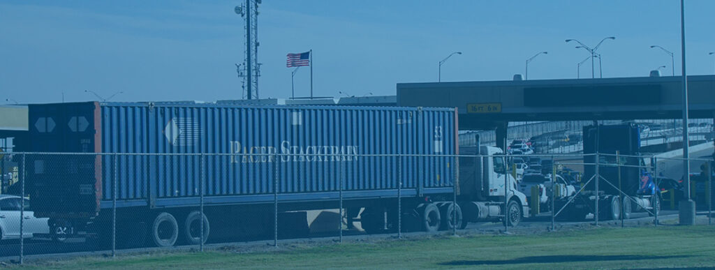 A freight truck transporting a container across the border