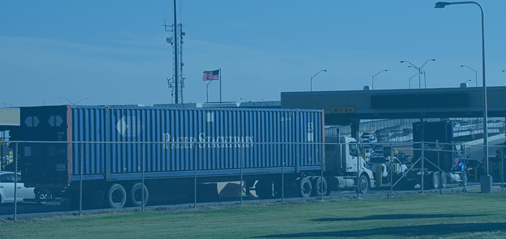 A freight truck transporting a container across the border