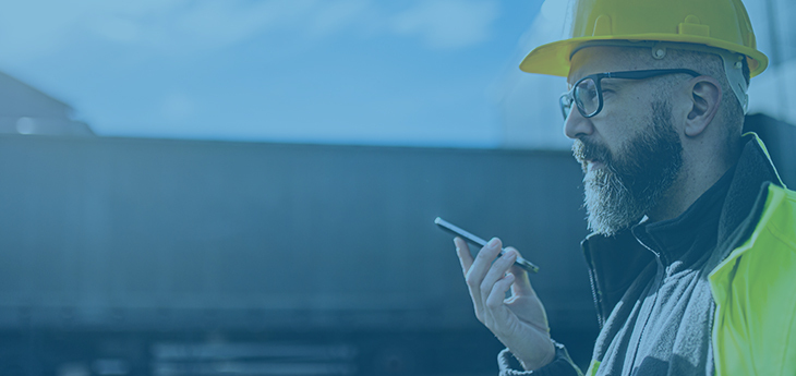 Warehouse worker with helmet talking into phone