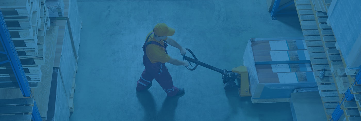 Dock worker moving a pallet via pallet jack